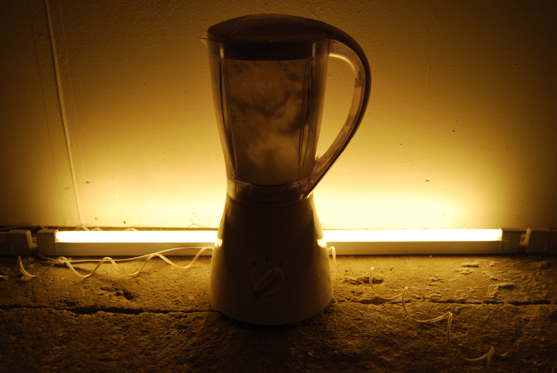 a blender in front of a fluorescent bulb